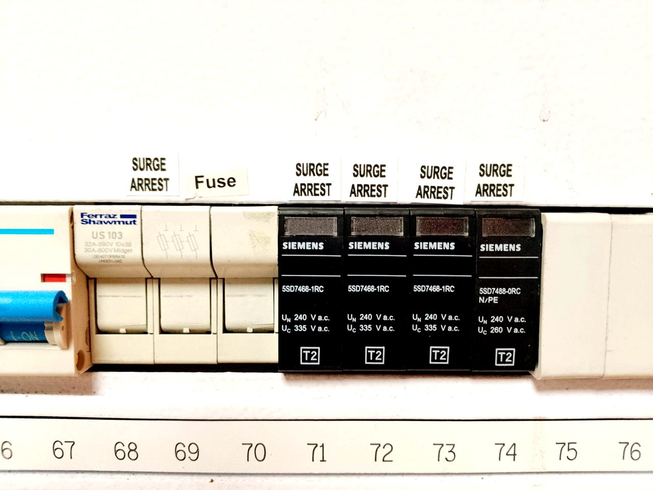 Close-up of Siemens surge-arrest and fuse modules mounted in a numbered distribution board.