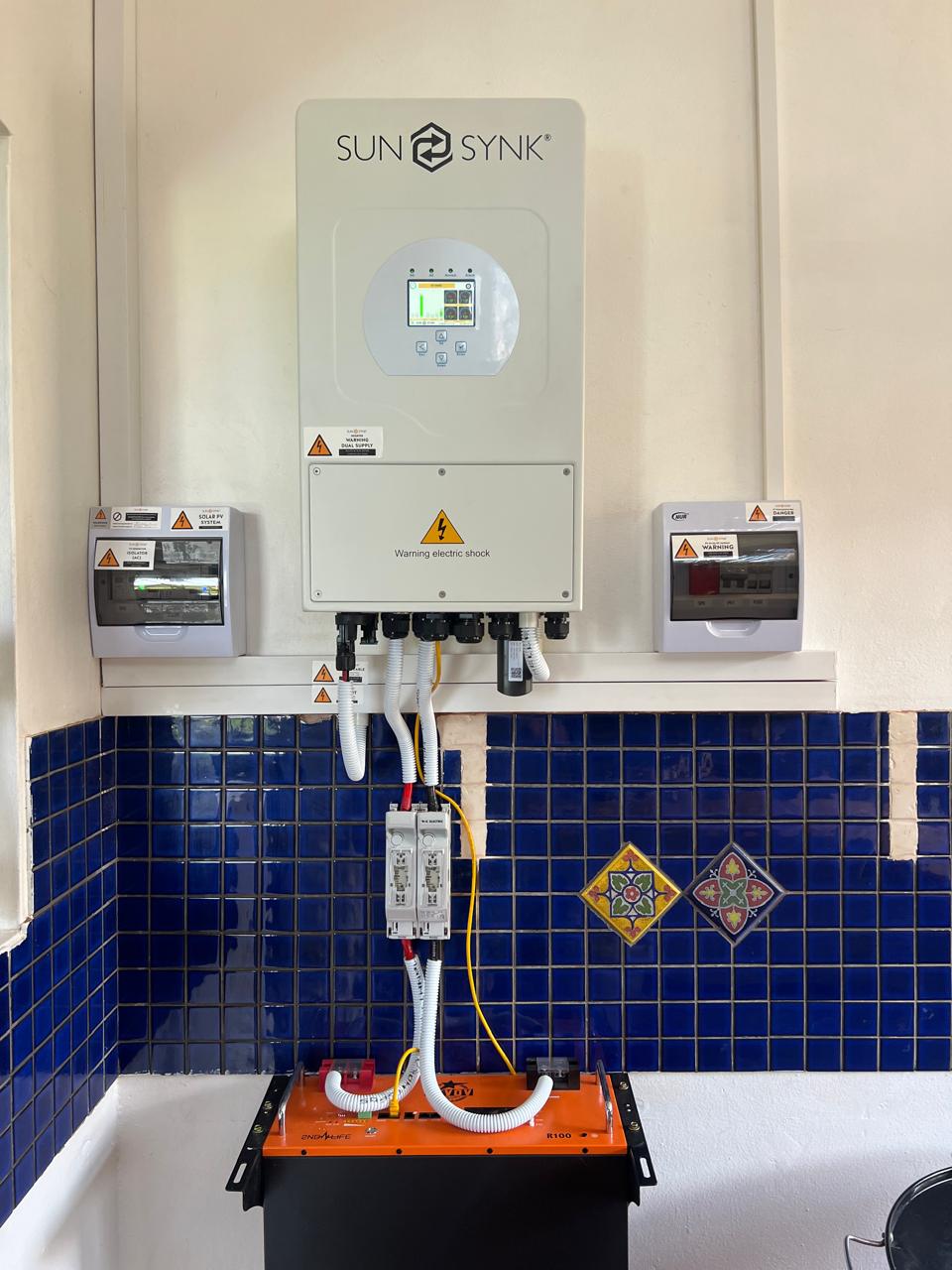 Sun-Synk inverter installed above a lithium battery unit, with circuit breakers mounted below.